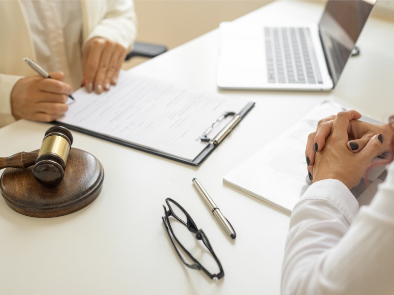 Une femme d’affaires et des avocats discutent d’un contrat.