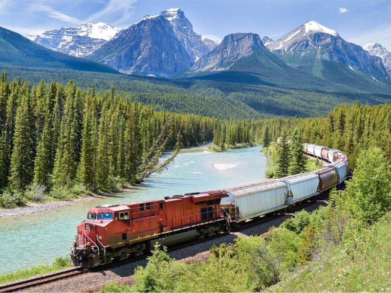 Train de marchandises circulant le long de la rivière Bow dans les Rocheuses canadiennes, Alberta, Canada.