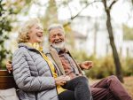 Couples aînés heureux s’asseyant sur le banc dans le stationnement.