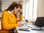 Jeune femme caucasienne inquiète organisant les finances de la maison.