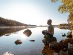 Homme méditant par le lac après un exercice extérieur.