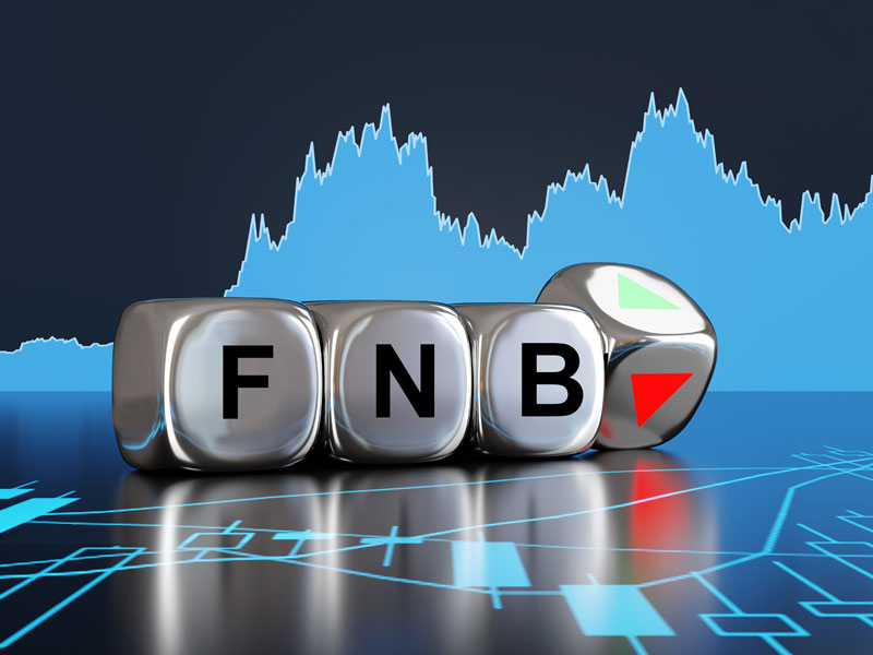 Des dés sur des graphiques de la Bourse montrant les lettres FNB.