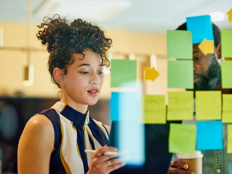 Deux professionnels discutent d’idées dans un bureau.