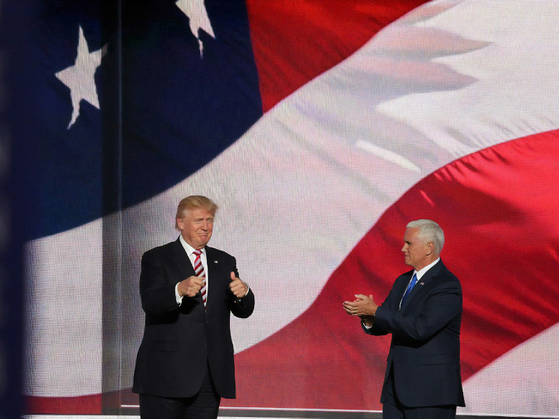 Donald Trump sur une scène devant le drapeau américain.